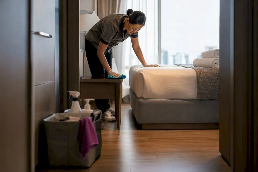 Cleaner inspecting a serviced apartment turnover