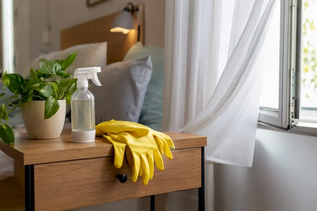 Open window with gloves and spray bottle for safe cleaning