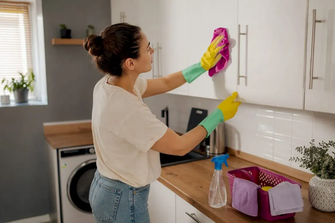 Tenant cleaning kitchen cupboards