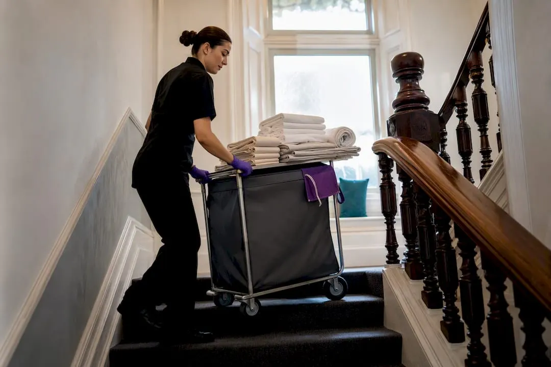 Cleaner moving linen trolley upstairs