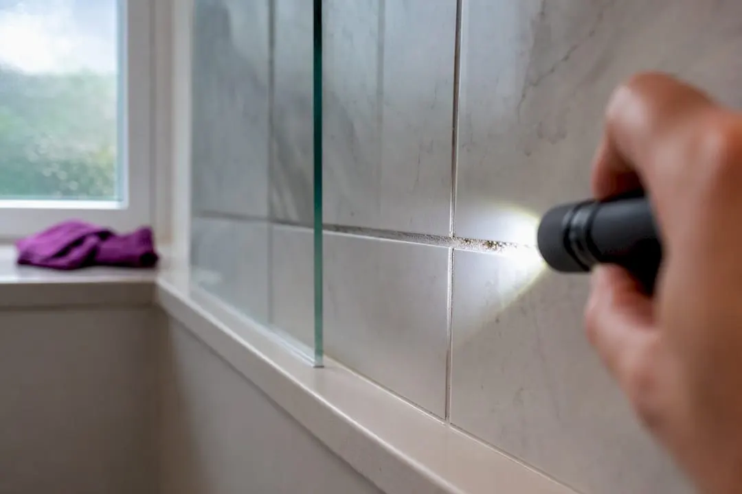 Torch revealing grime on bathroom grout