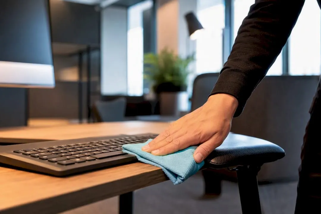 Cleaner disinfecting a shared hot desk