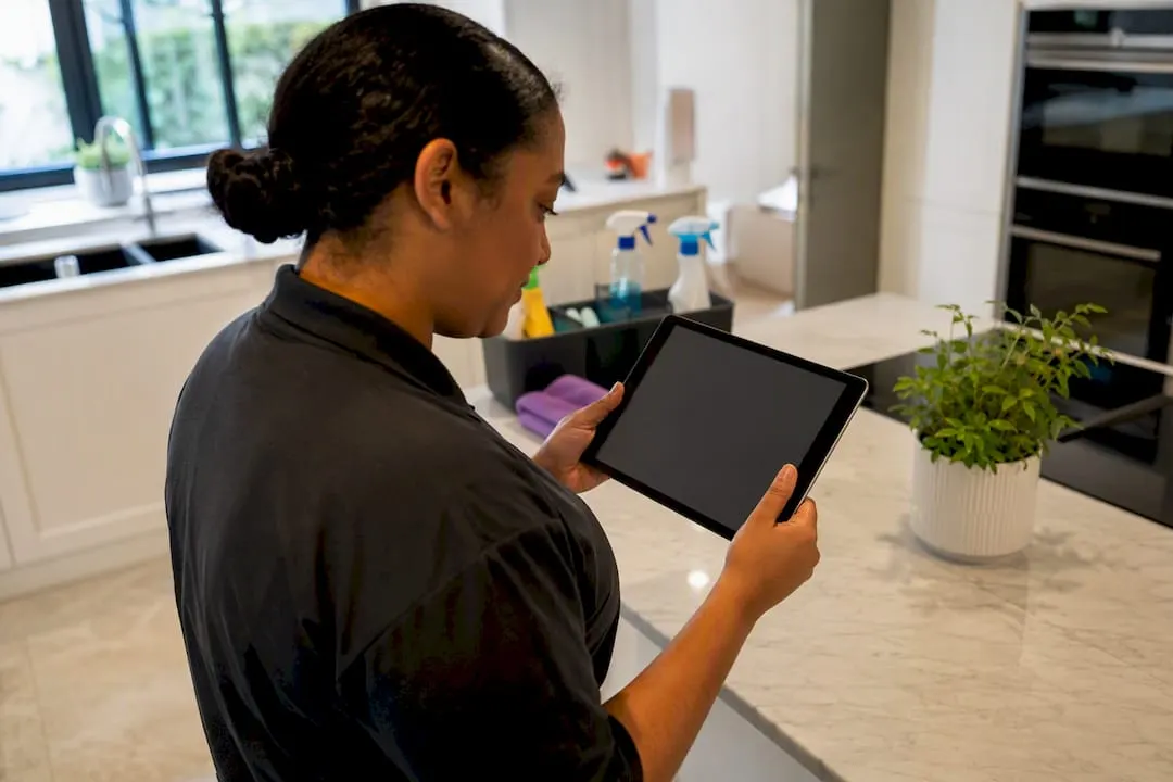 Cleaner checking insurance documents on tablet